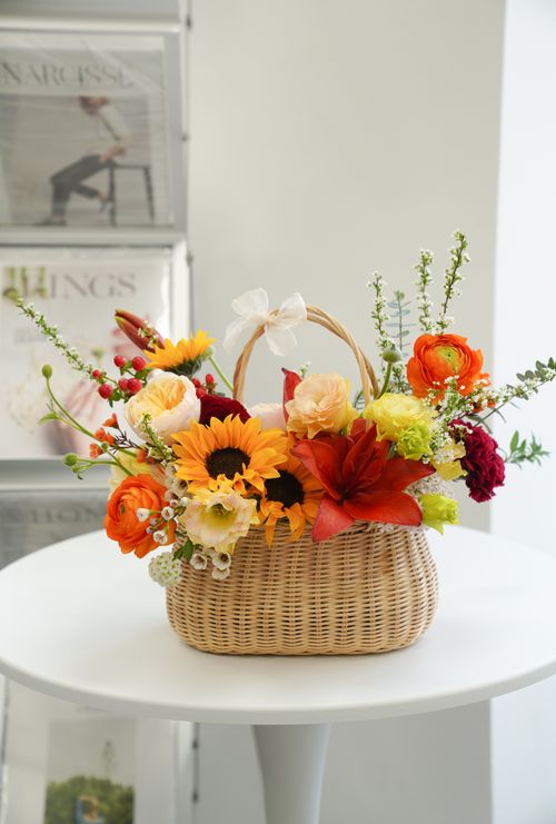 Free Colorful floral arrangement with sunflowers, carnations, and more in a wicker basket. Stock Photo