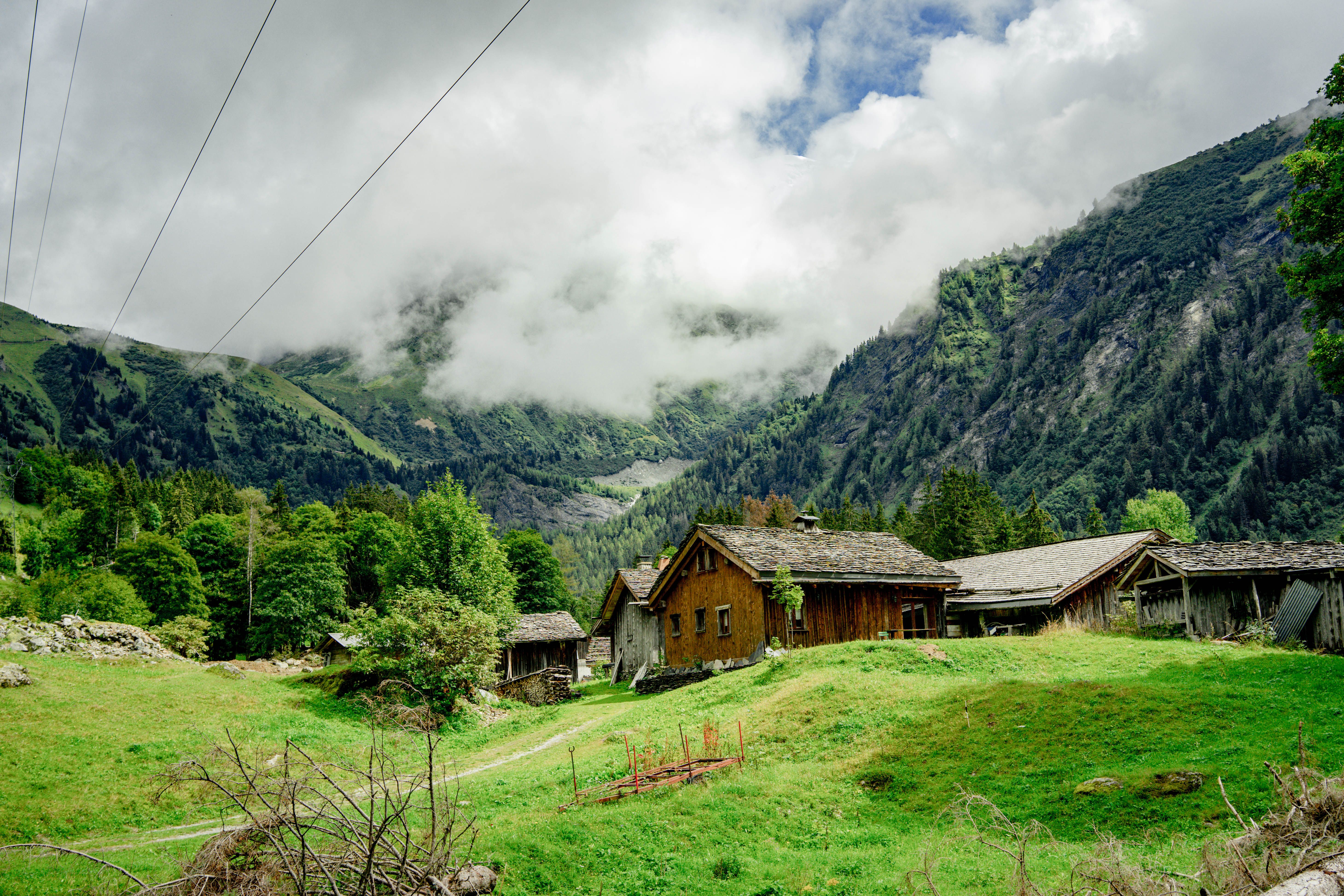Wooden Houses on Green Hill in Mountains Landscape · Free Stock Photo