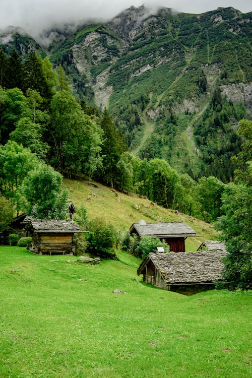 Houses on Green Hill in Mountains Landscape