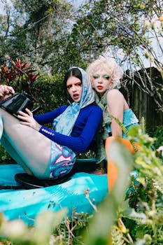 Two stylish women in a vibrant garden setting showcasing colorful fashion and makeup.