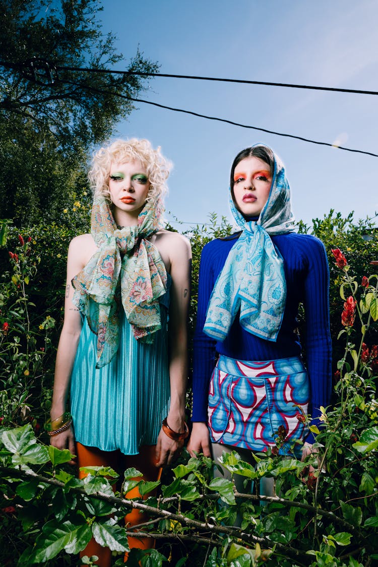 Women Wearing Colorful Clothing Standing In A Garden