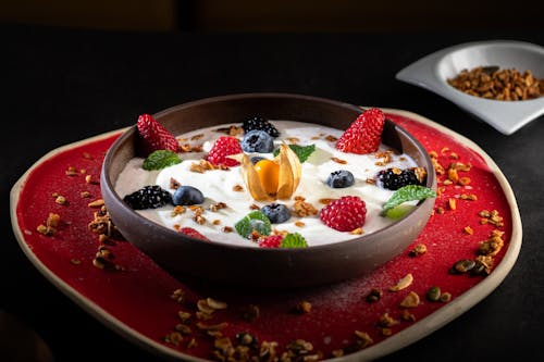 Delicious Granola with Yogurt and Fruits on Table