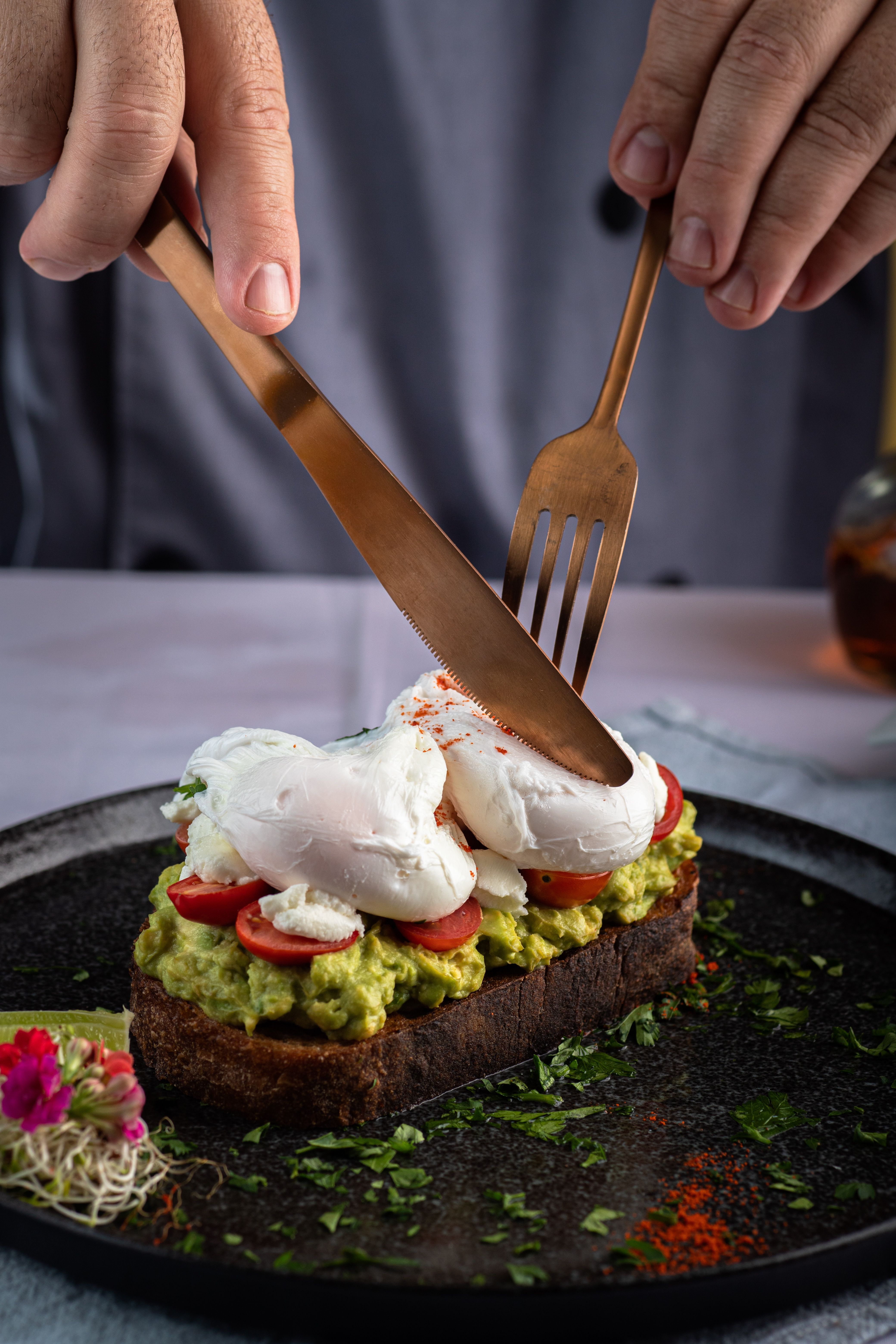 Close-up of avocado toast with poached eggs and tomatoes. A gourmet culinary presentation.
