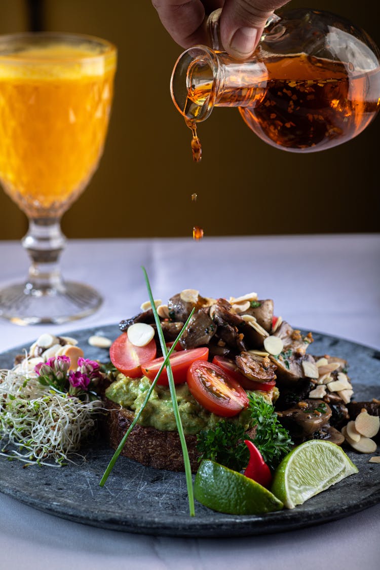 Person Pouring Olive Over Salad