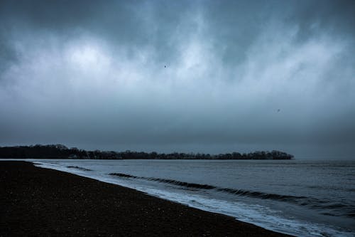 View of a Beach and Sea under a Dark, Cloudy Sky