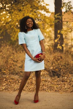 一位穿着蓝色连衣裙和红色高跟鞋的优雅女士，正在阳光明媚的户外享受时光