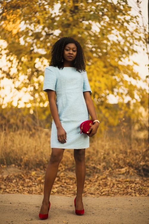 Woman in Blue Dress Holding Red Bag