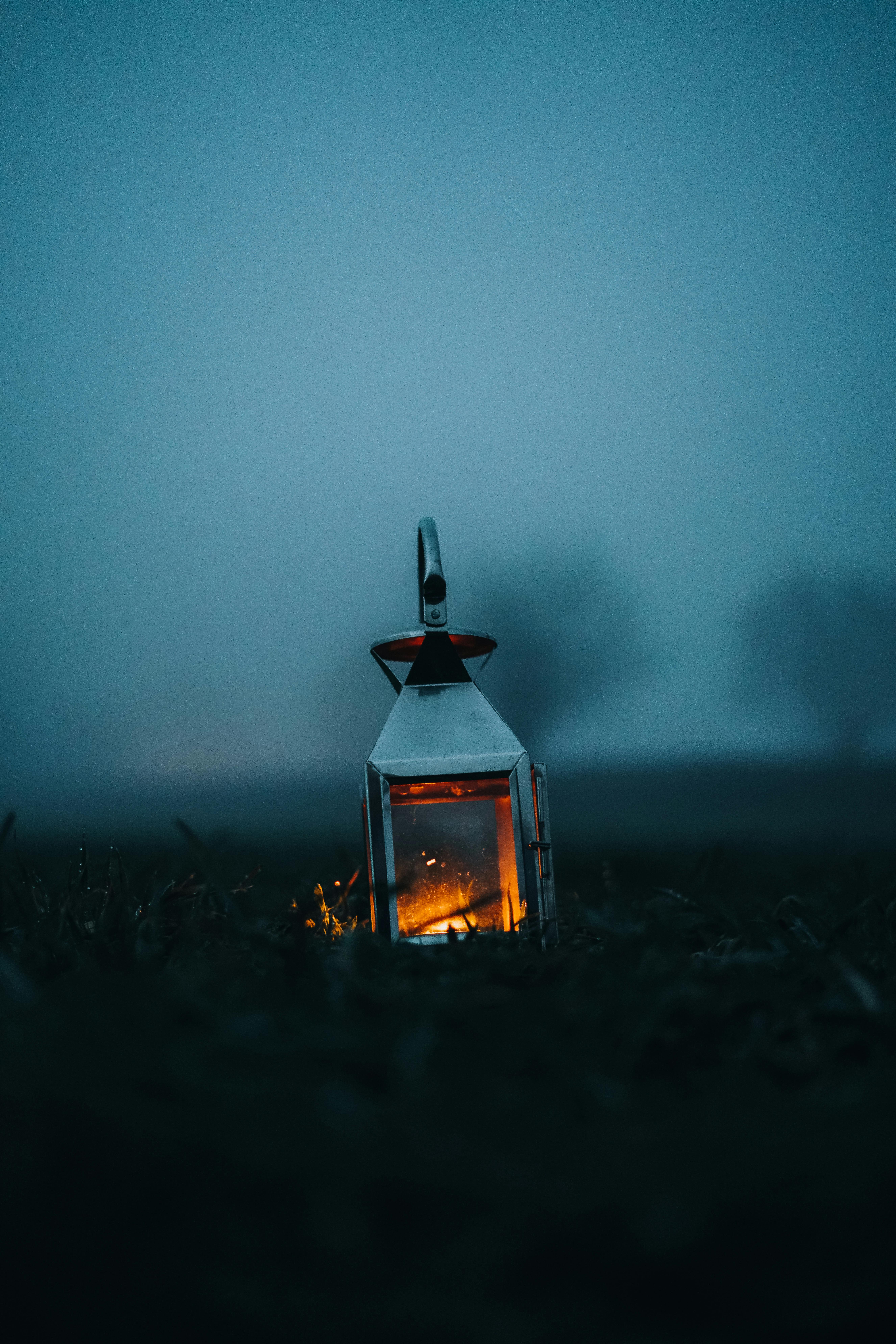 Tranquil scene of a lantern illuminating a rural field in England, United Kingdom, at dusk.