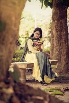 在南亚，一位妇女在宁静的户外公园长凳上读书