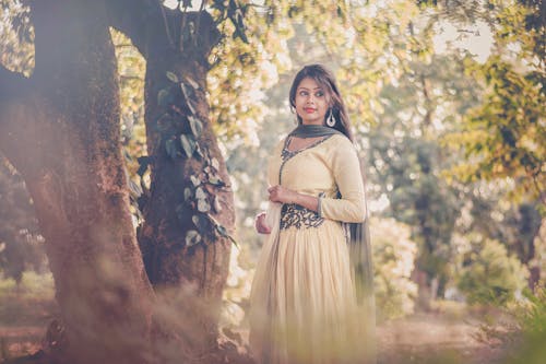 Mujer Con Vestido Amarillo De Pie Junto A Un árbol