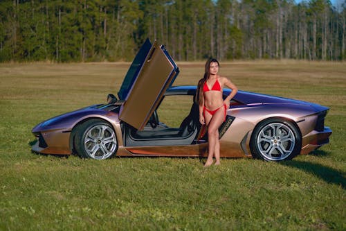 Free Woman Standing next to Luxury Car Stock Photo