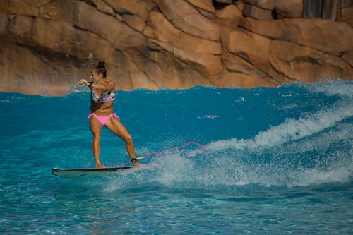 Woman Surfboarding in Turquoise Water 