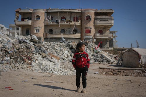 Girl Standing amid Earthquake Rubble 