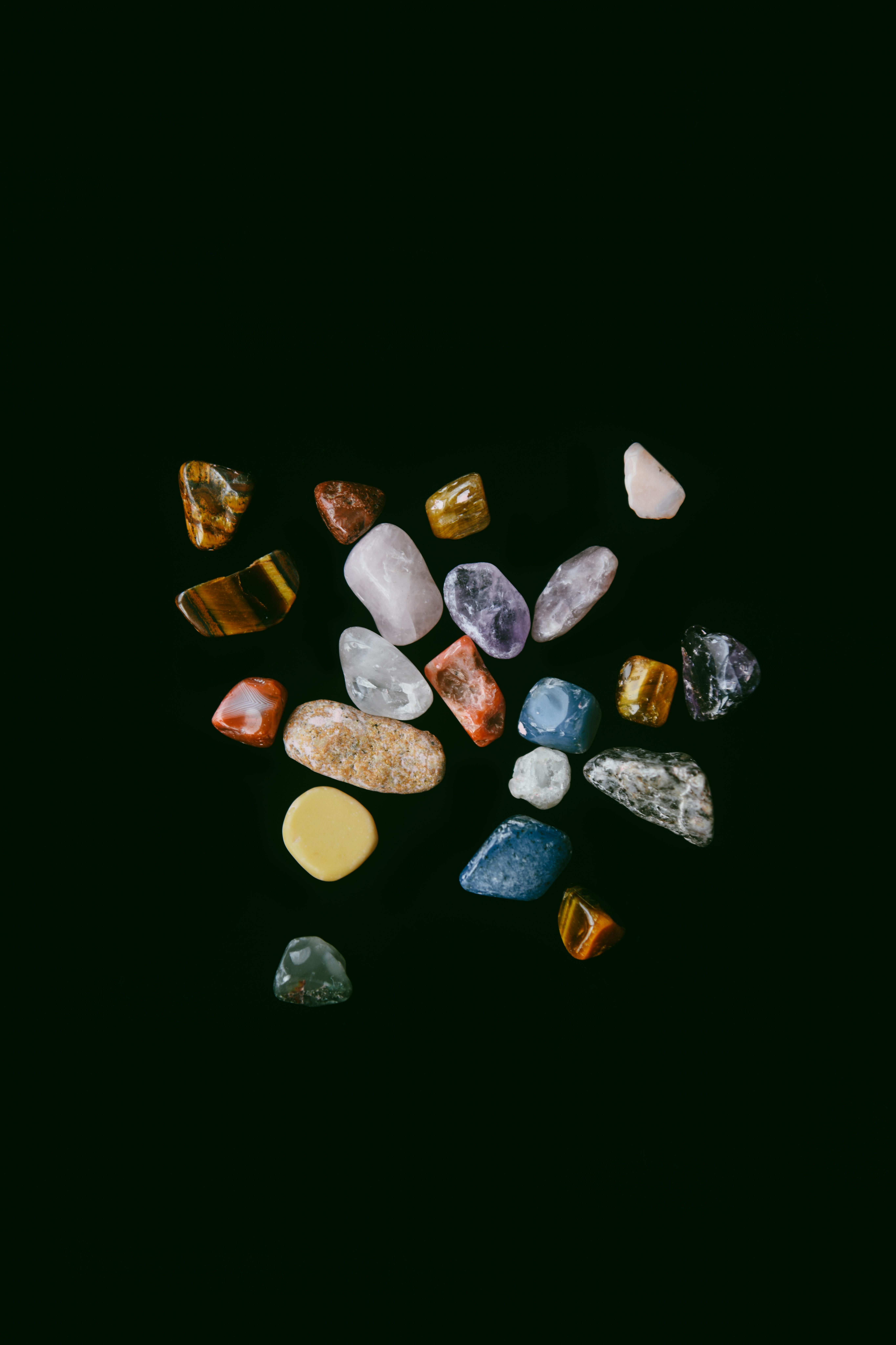 A diverse collection of colorful minerals and gemstones on a dark studio backdrop.