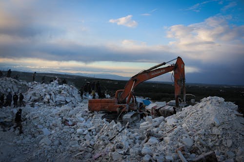 An Excavator among Building Ruins 