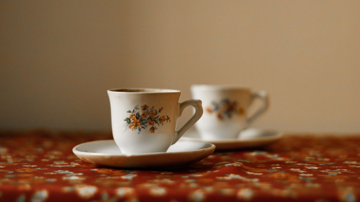 Photo: Feyza Daştan / Pexels Two floral teacups on a patterned tablecloth in soft window light