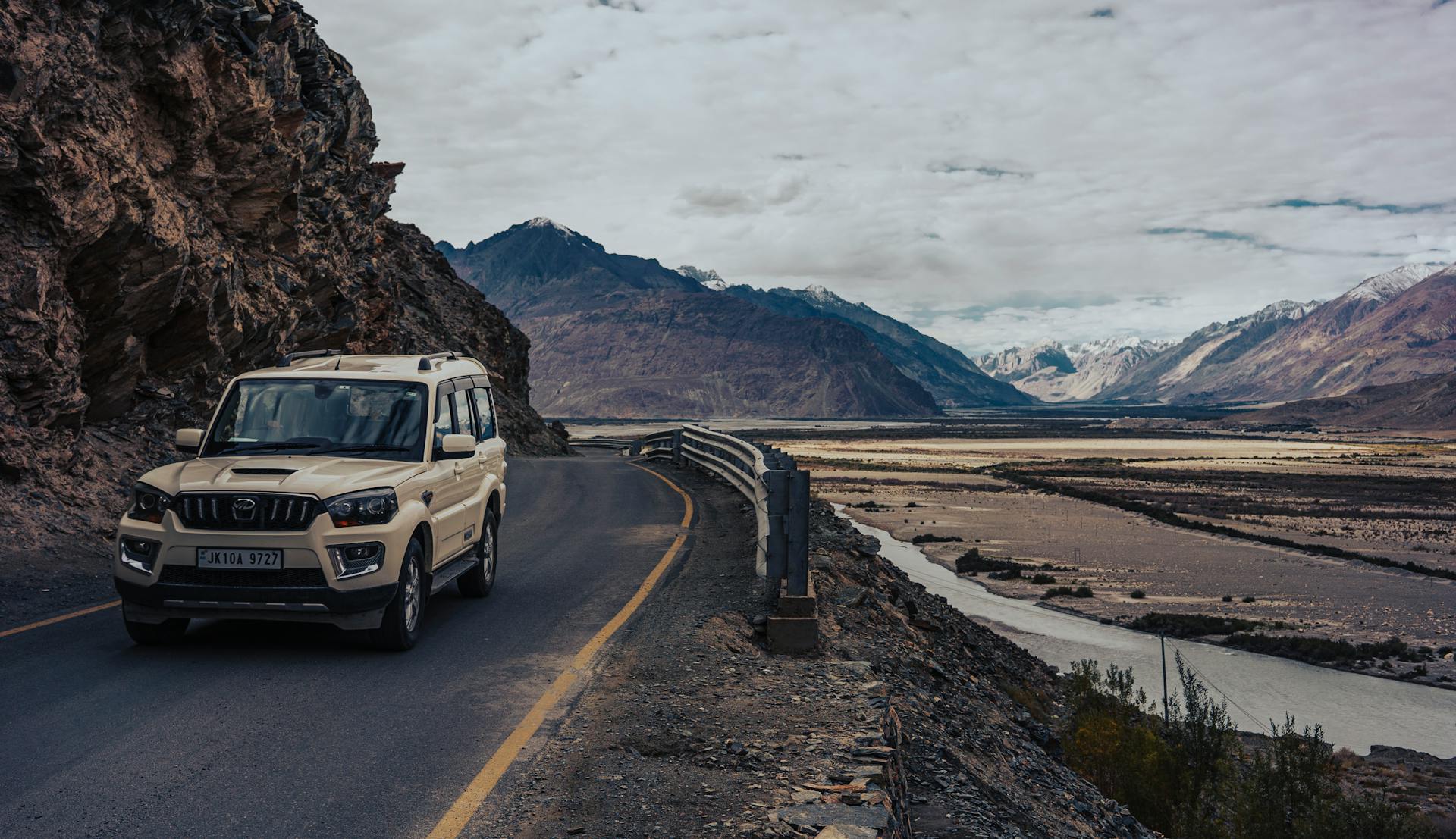 Explore the rugged terrain of Ladakheda, India, with a 4WD adventure vehicle on a mountain road.