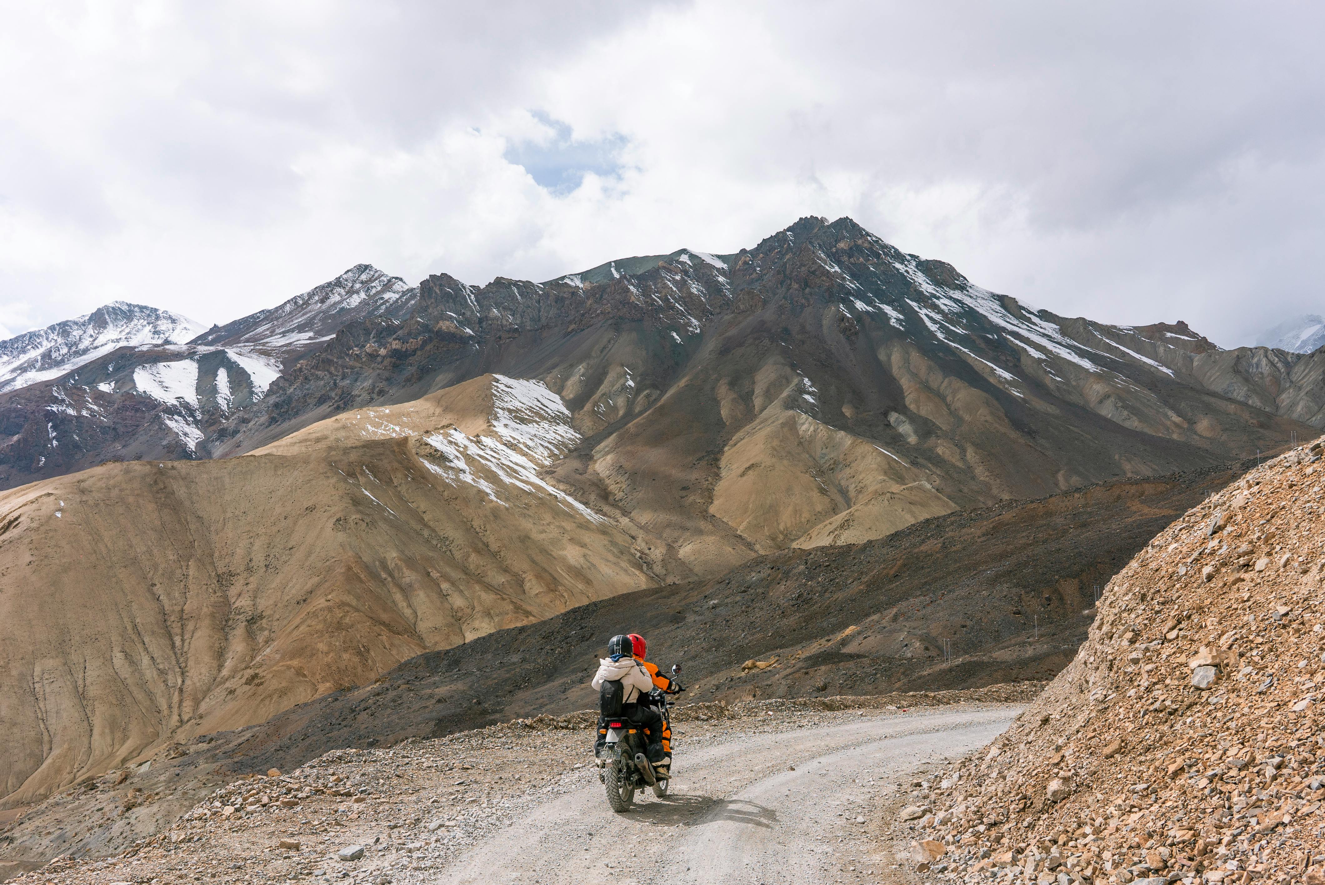 people together on motorcycle on road in mountains