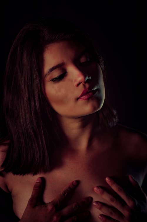 Free Artistic low-light studio portrait of a young woman with closed eyes and serene expression. Stock Photo