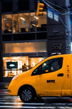 Yellow NYC taxi speeding through New York's bustling urban streets, capturing the essence of city life.
