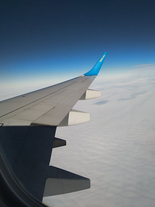 View of White Clouds and Blue Sky from an Airplane Window 
