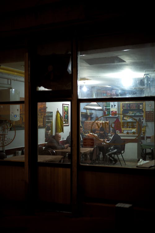People Sitting in a Small Cafe at Night