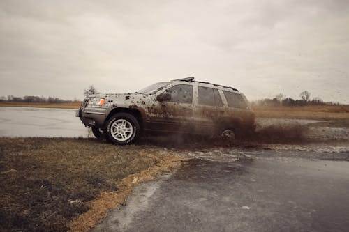 A suv driving through mud in the middle of a field