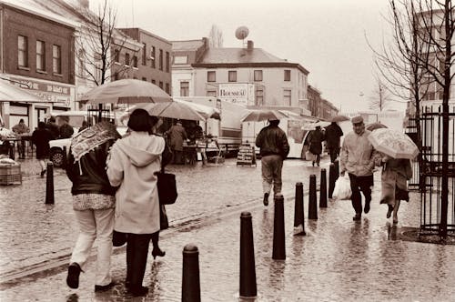 People Walking on the Street in Rain in Sepia