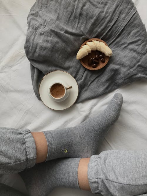 Feet next to a Cup of Coffee 