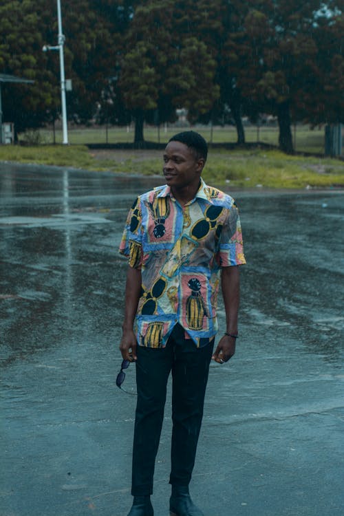 Young Man in Shirt Standing on Street After Rain