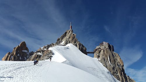 白天，人們在積雪覆蓋的地面上走向山頂