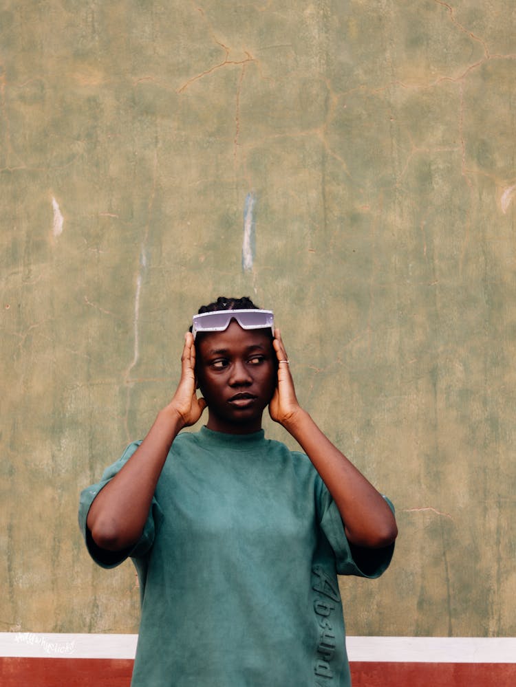 Woman With Glasses On Her Head And Hands On Her Ears 