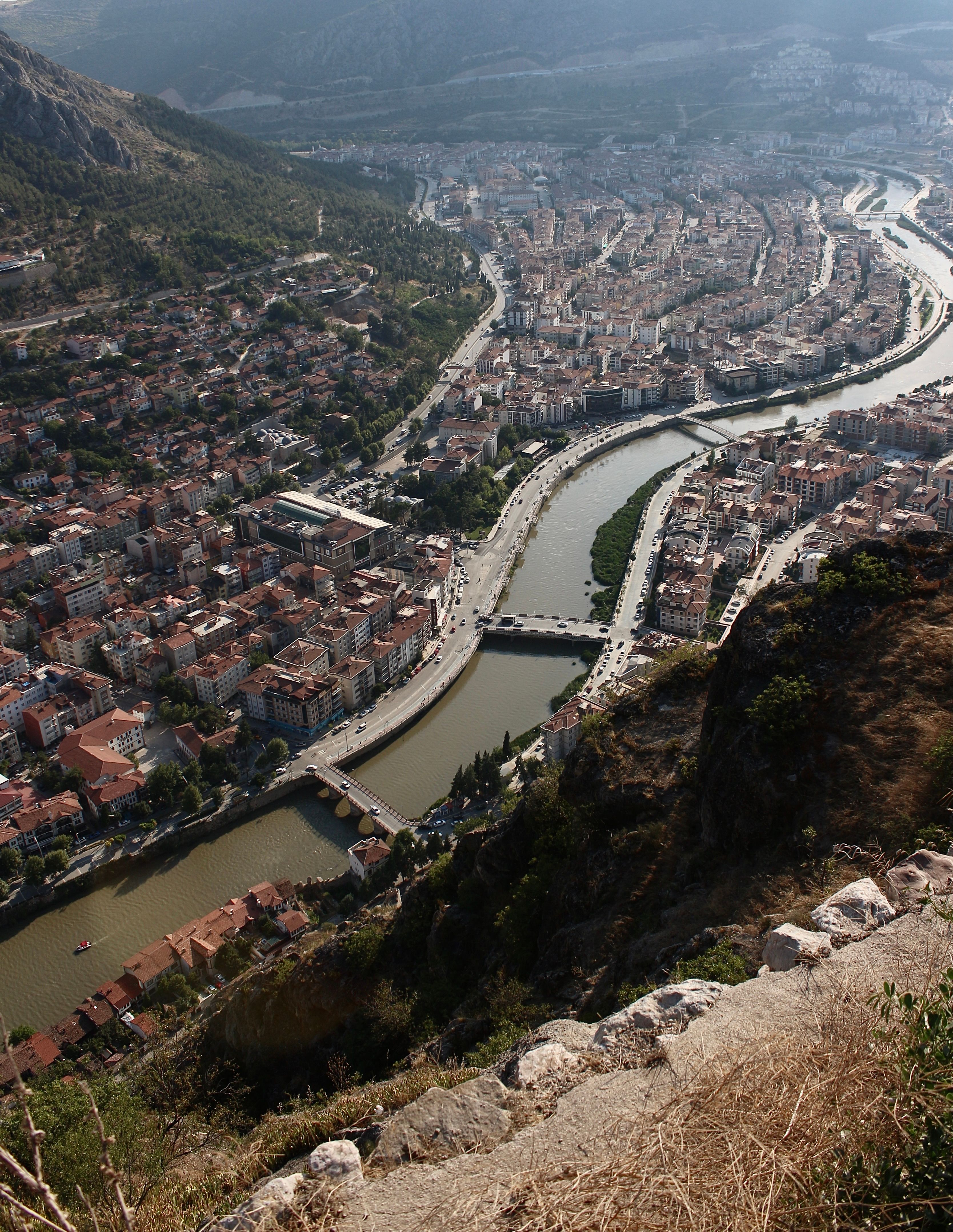 Discover a vibrant riverside town nestled in a picturesque valley from above.