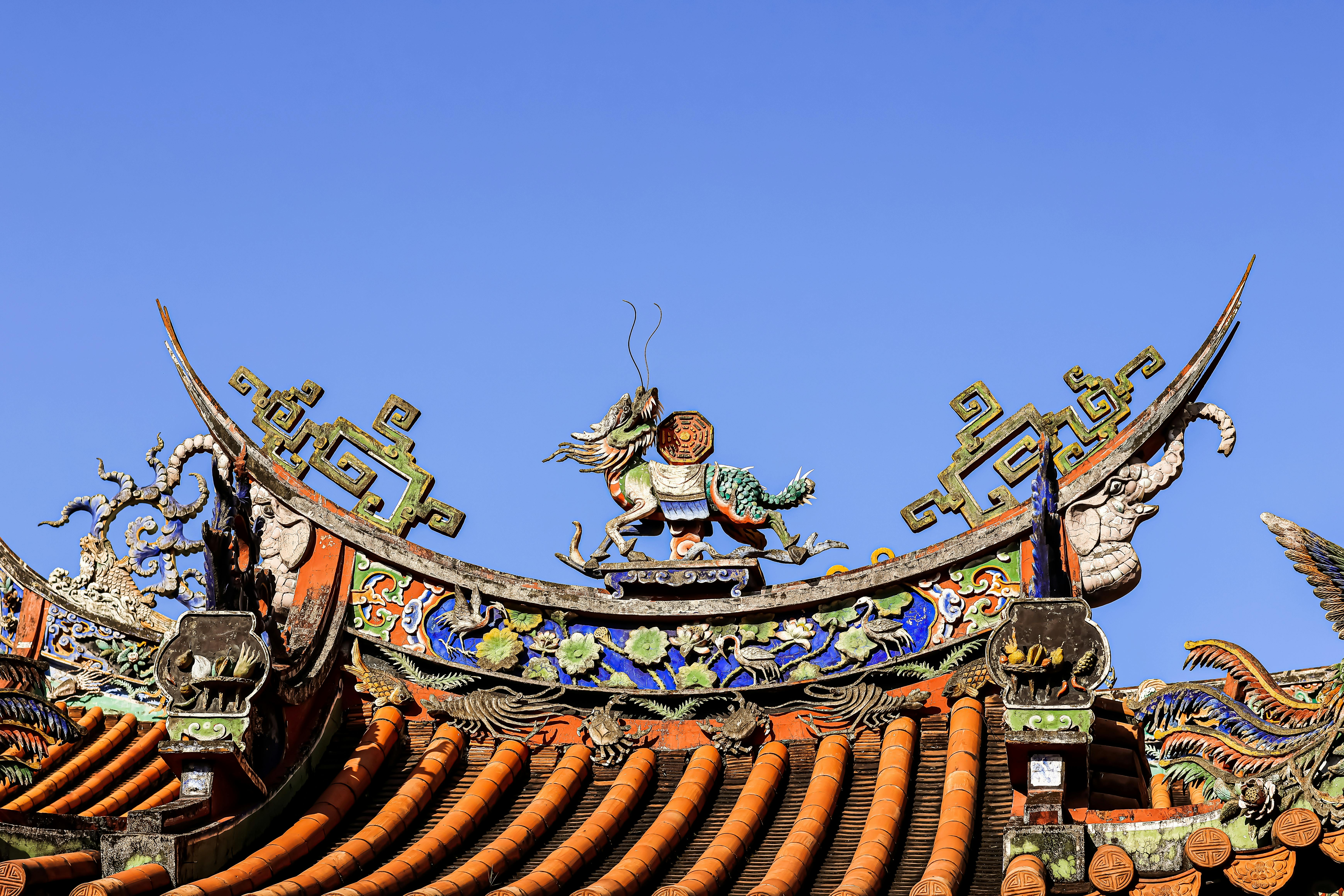 Detailed view of traditional Taiwanese temple rooftop with vibrant dragon motifs in Taipei, Taiwan.
