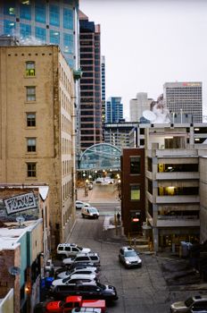 Elevated view of a city alleyway with parked cars and tall buildings, showcasing downtown architecture.