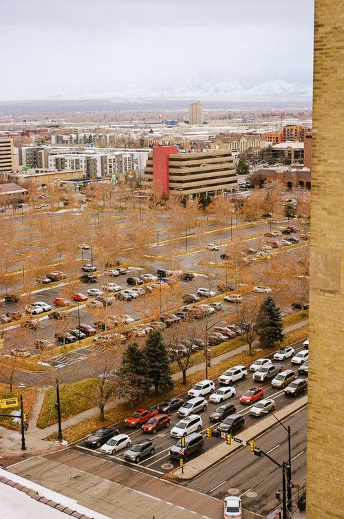 Free Aerial view of city intersection in autumn with parked cars and urban buildings. Stock Photo