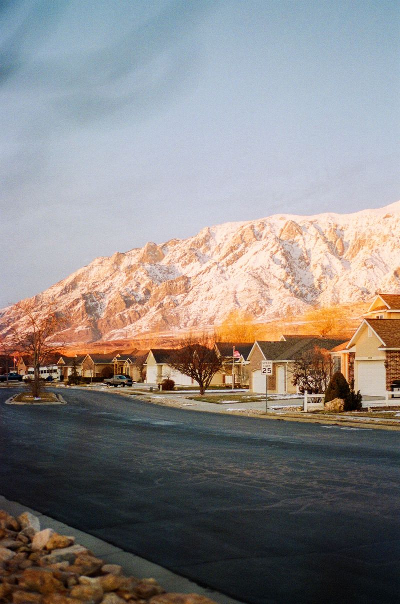 Suburban neighborhood street with mountains glowing at sunrise