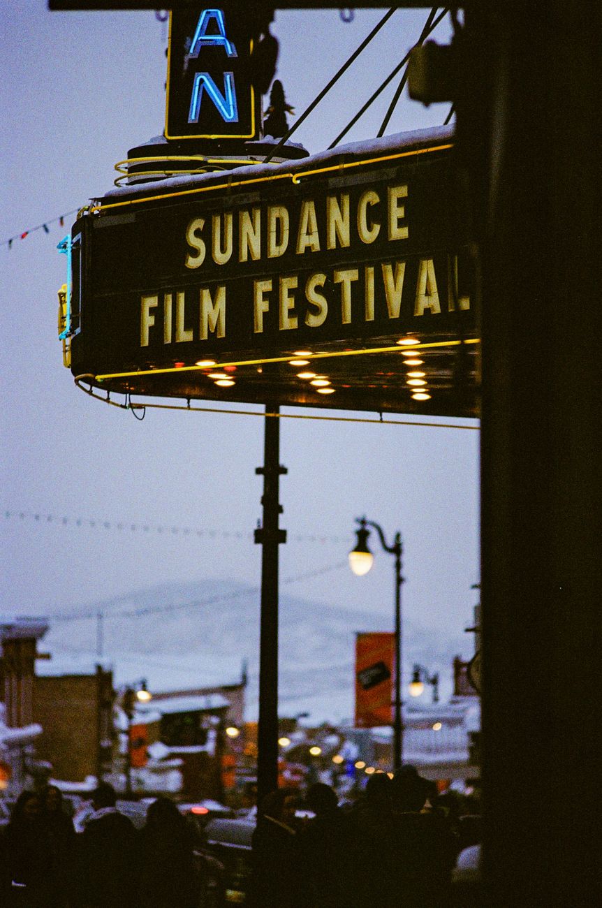 Sundance Filmfestival marquee op een met sneeuw bedekte straat met mensen en lichten op de achtergrond.