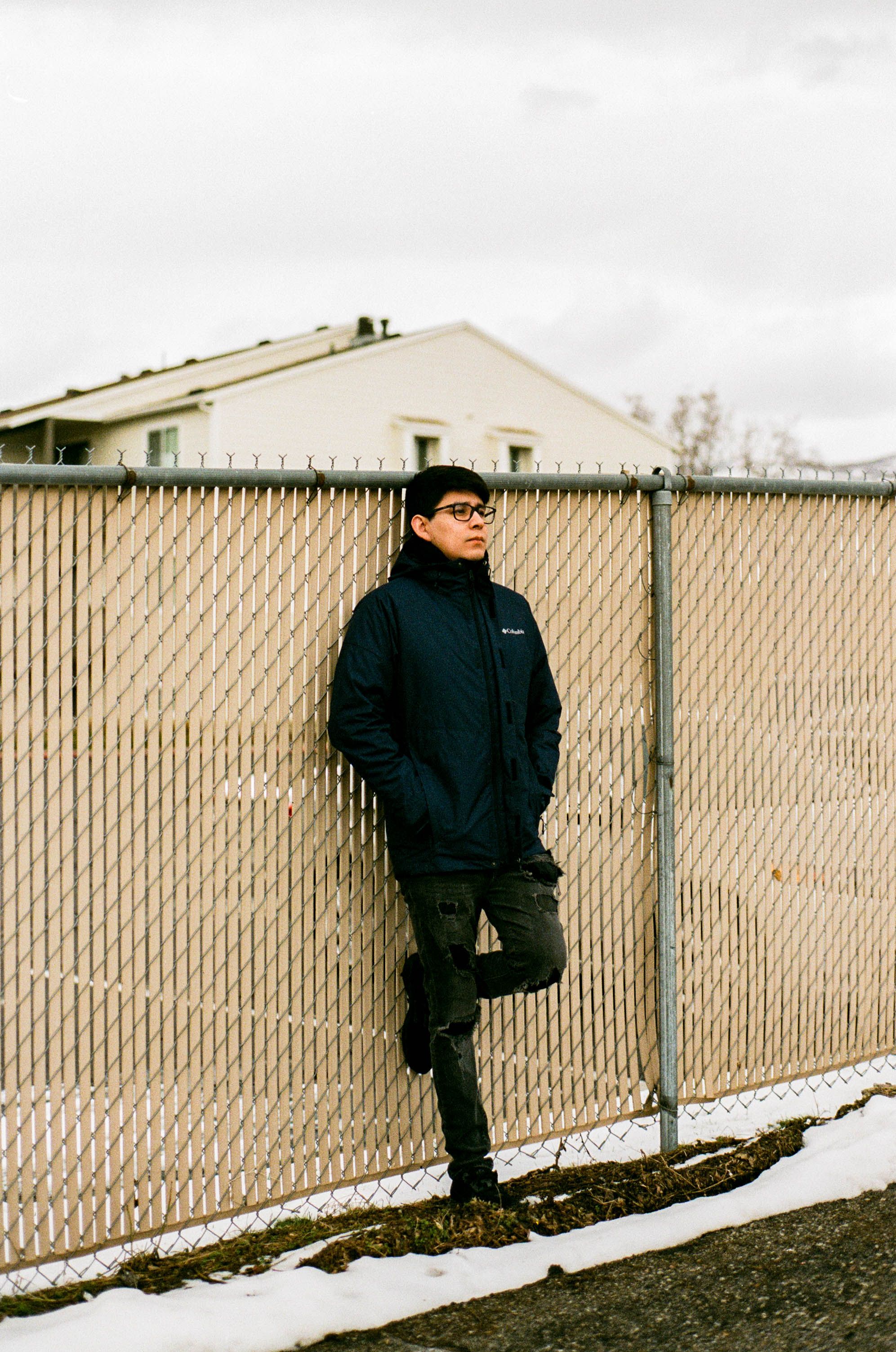 Man Leaning Against a Fence · Free Stock Photo