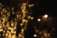 黑暗背景下，模糊的金色散景灯光令人着迷