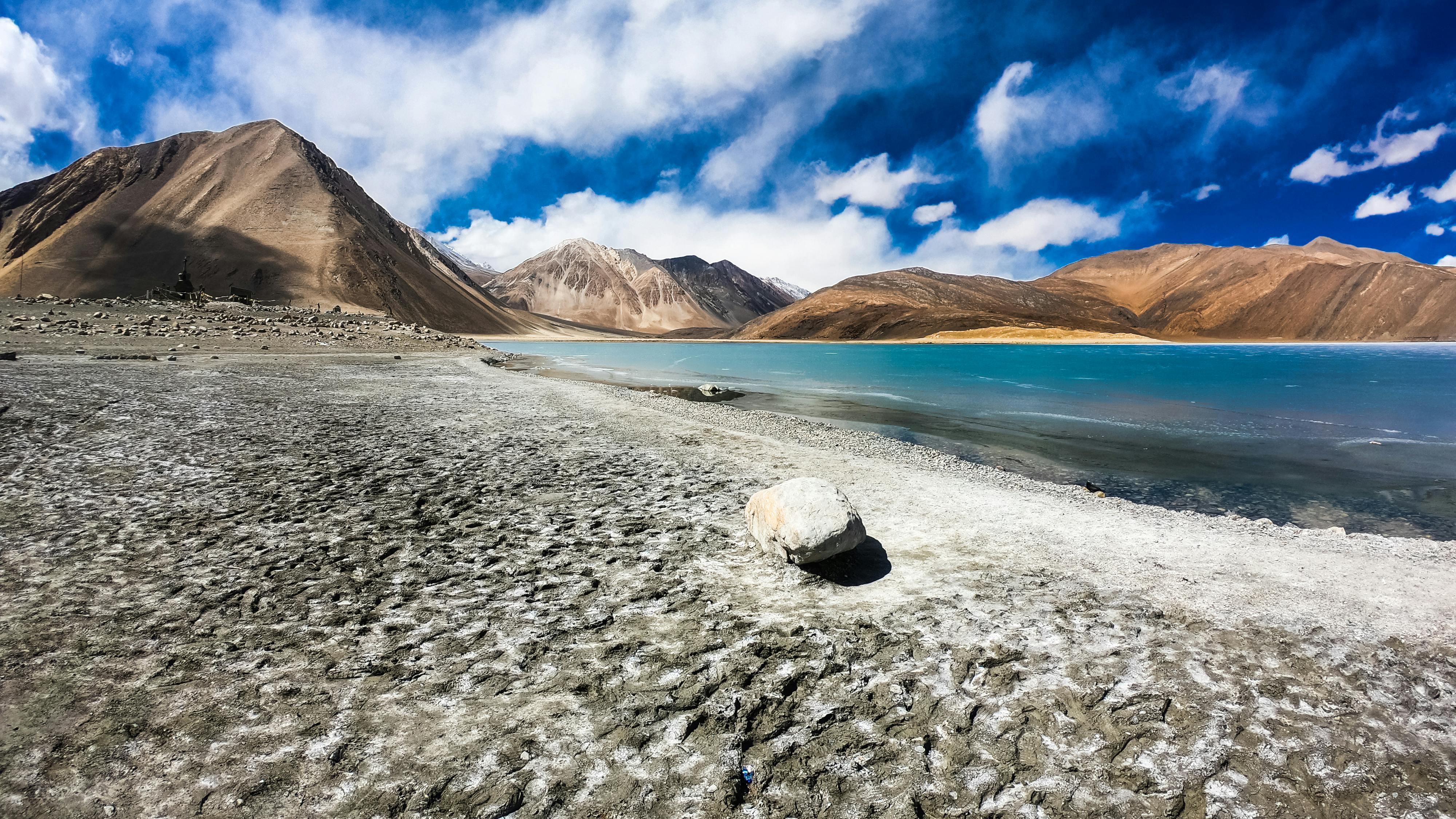 Grey Rock Near Blue Body of Water Under Blue and White Sky · Free Stock ...