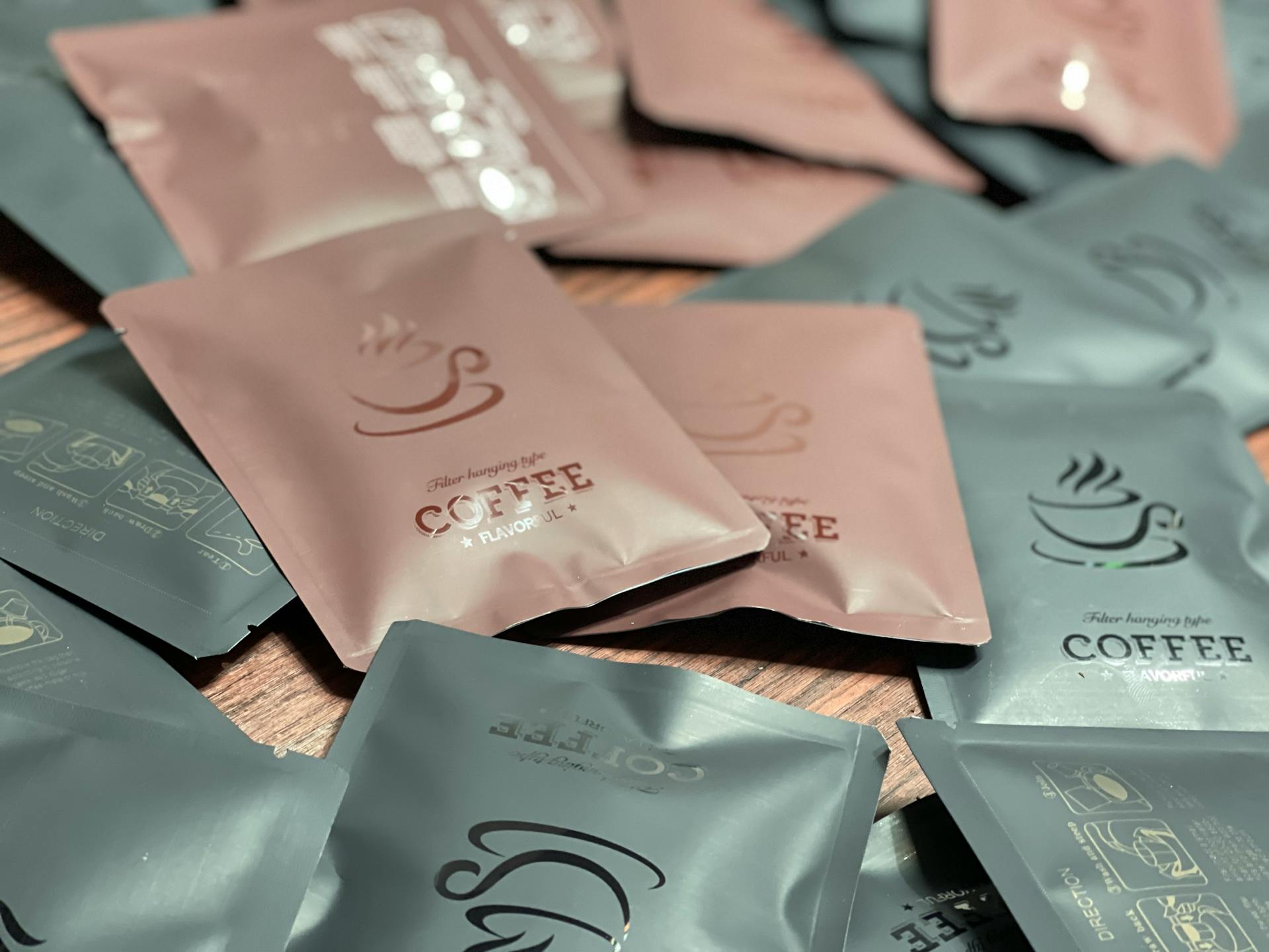 Close-up of various packaged coffee sachets on a wooden table, showcasing instant coffee options.