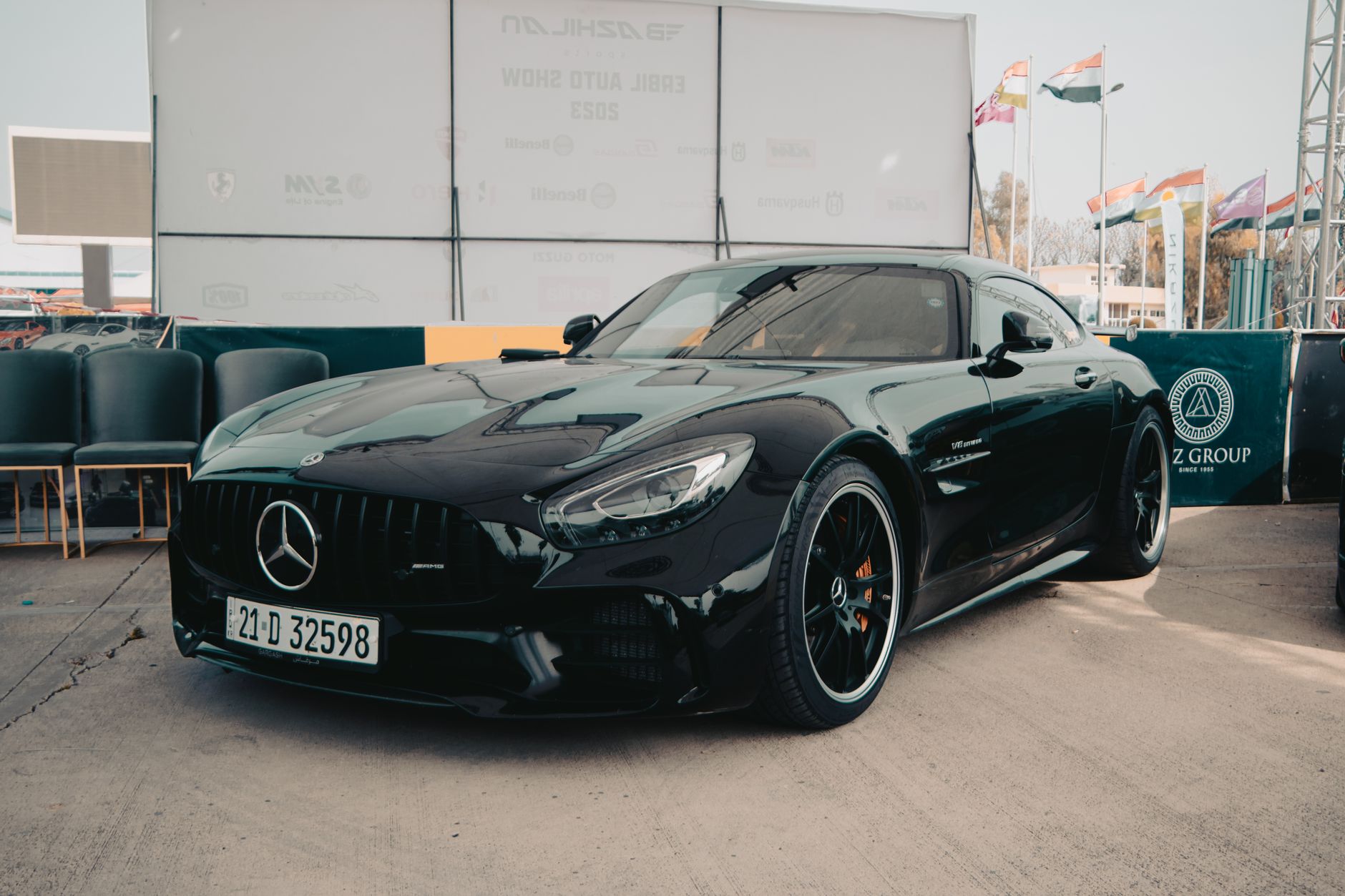 Elegant black Mercedes Benz GT car showcased at an outdoor auto show.