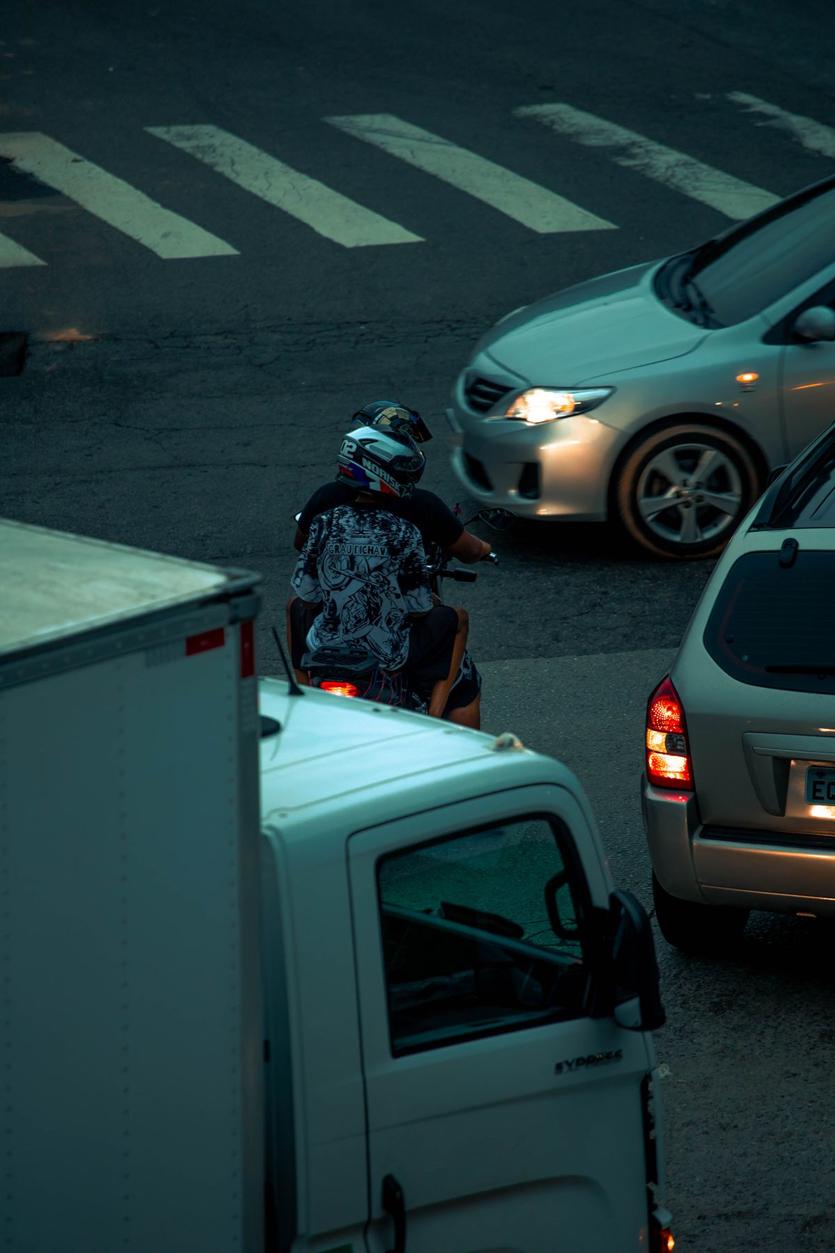 Tránsito urbano con automóviles y motocicleta circulando por una vía