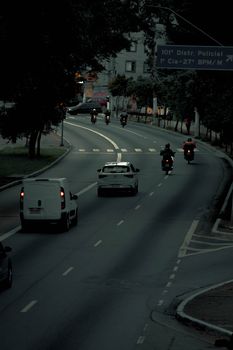 City street at dusk with motorcycles and cars, creating an urban ambiance