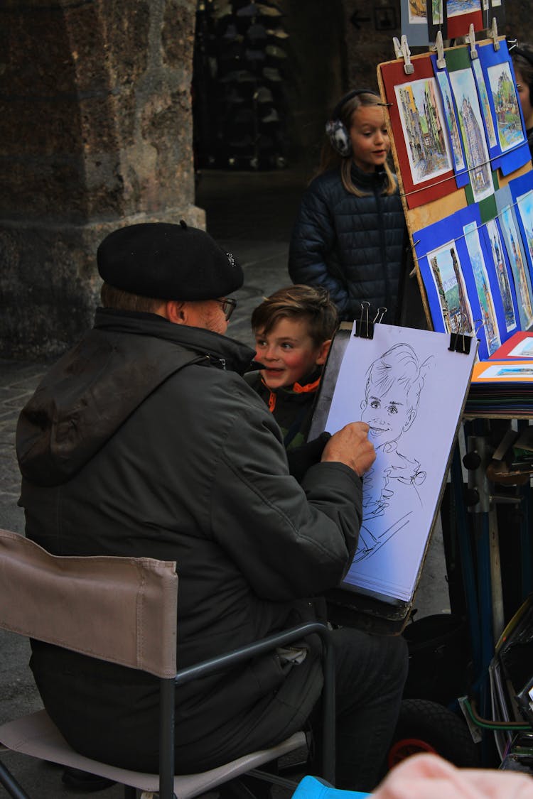 Man Sitting On Chair And Drawing Boy