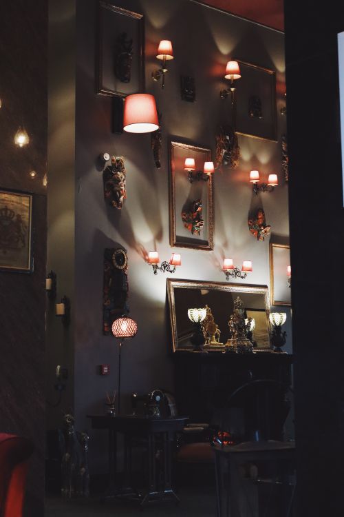 Free Elegantly decorated room with vintage frames and warm lighting, creating a cozy atmosphere. Stock Photo