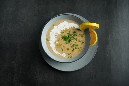 A delicious creamy soup garnished with fresh parsley and lemon slice.