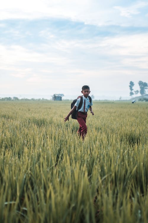 A Boy in a School Uniform on a Grass Field 