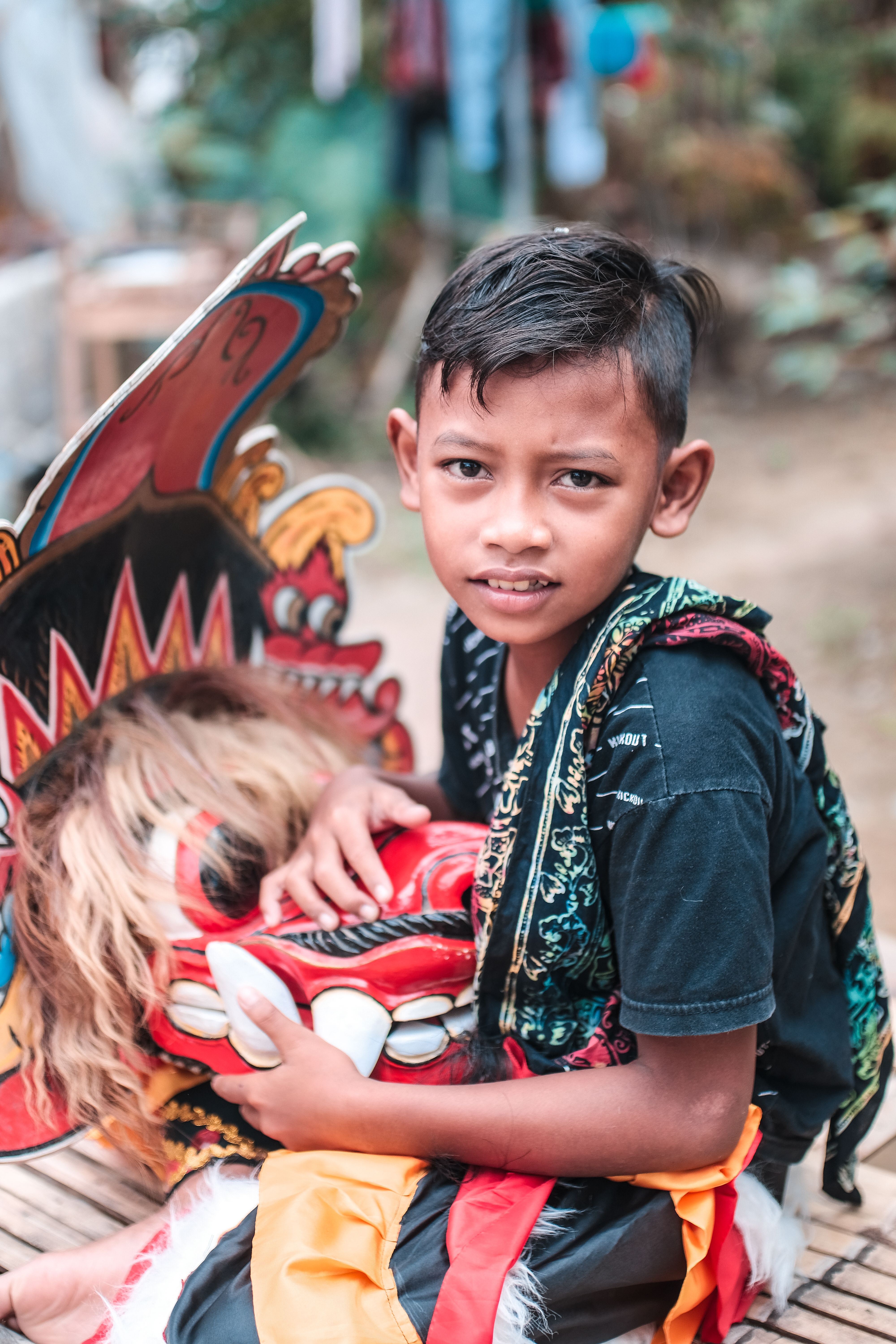 A Boy in a Costume Holding a Mask · Free Stock Photo